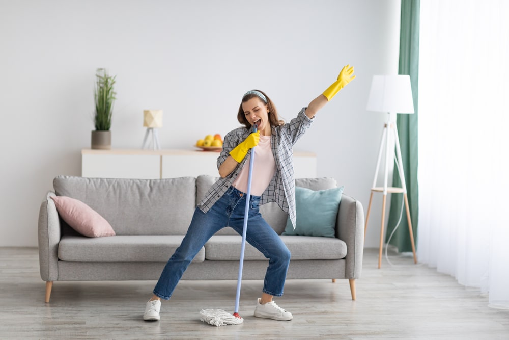 Happy,Young,Woman,Cleaning,Her,Home,,Singing,At,Mop,Like